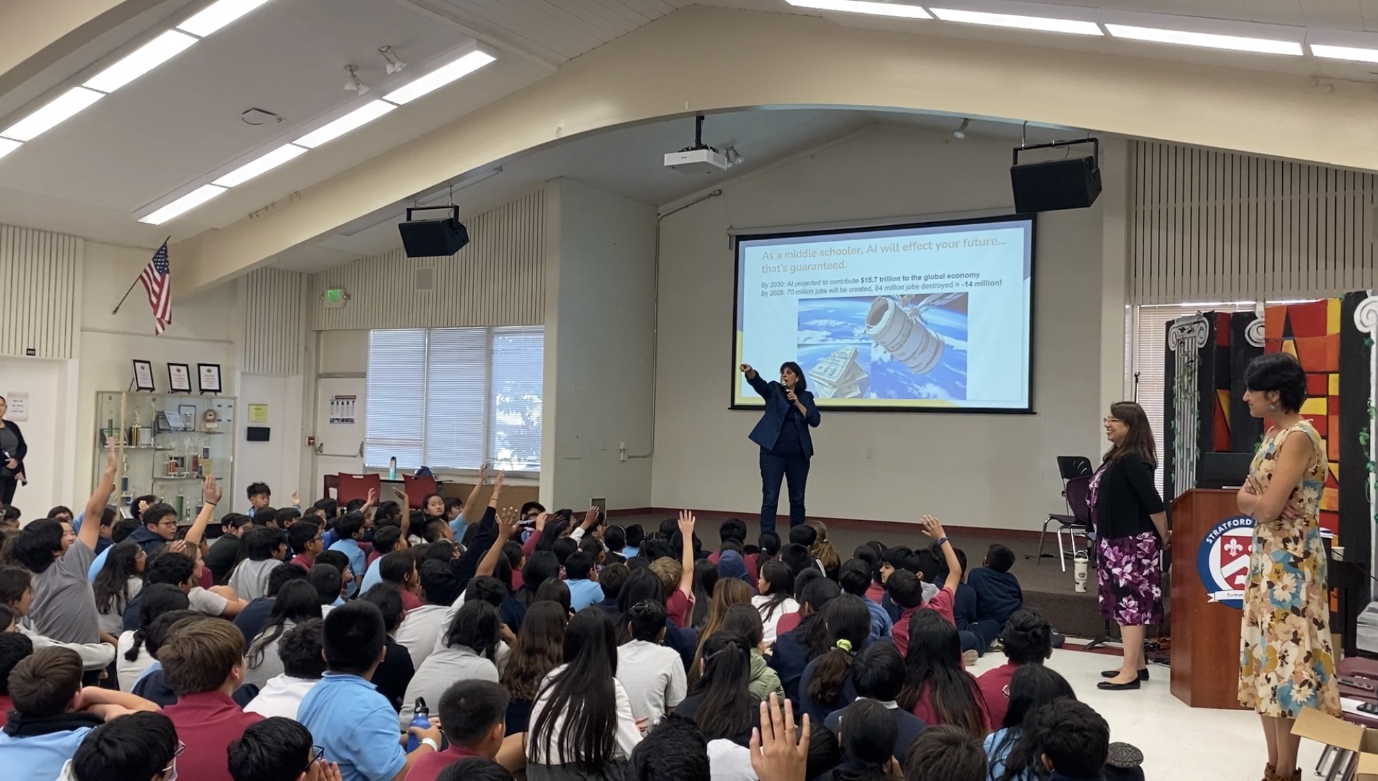 Discovering AI presenting to students in a school assembly
